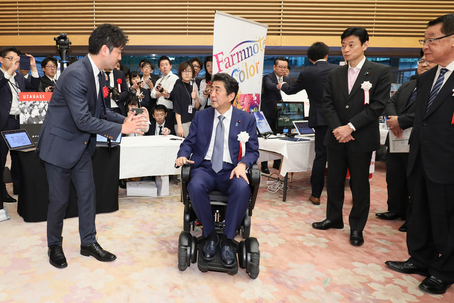 受賞者の展示ブースを観覧する安倍総理４