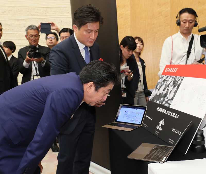 受賞者の展示ブースを観覧する安倍総理５