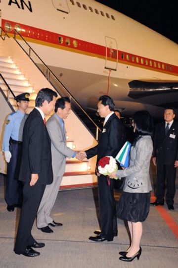 菅副総理と平野官房長官に見送られて出発する鳩山総理夫妻の写真